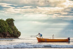 Lone fisherman casts net at sunrise in Puerto Viejo, Costa Rica by Tampa photographer Carver Mostardi.